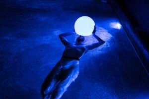 Objeto de iluminação flutuante para piscina sendo segurado por pessoa em cenário noturno